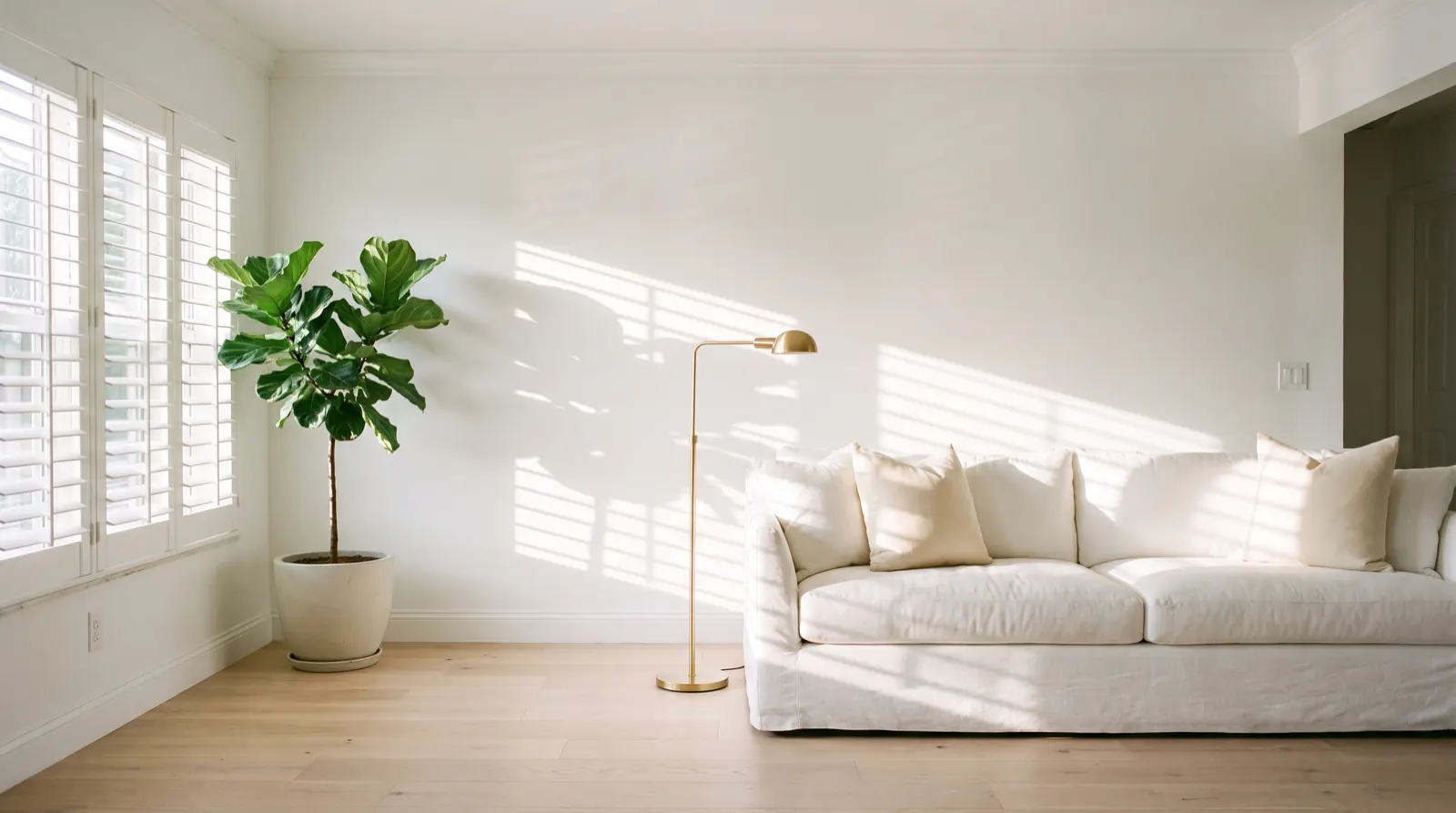A bright living room with a linen sofa and afternoon light falling through plantation shutters (illustrative)